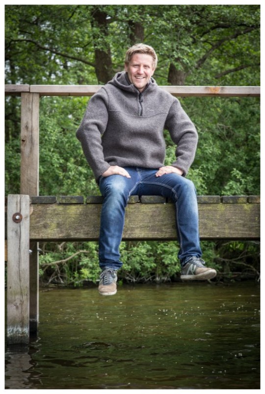 Mann mit Mufflon Jacke auf einer Bank