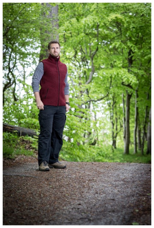 Mann mit Mufflon Weste im Wald