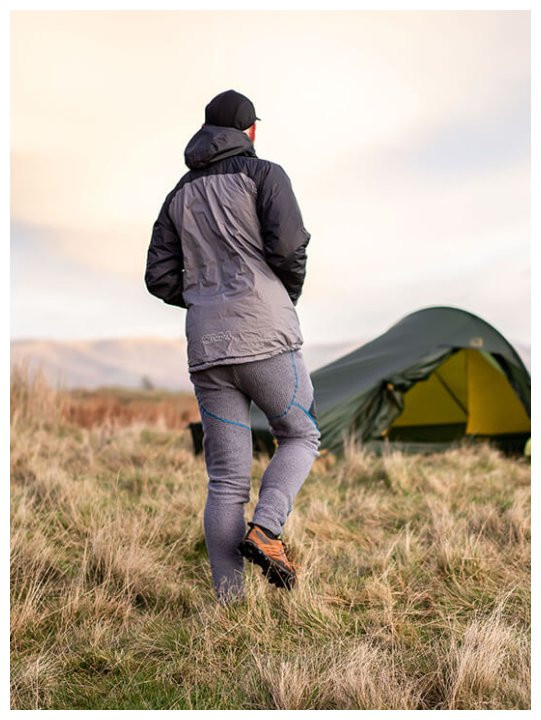 Mann in OMM Core Tights am Zelt