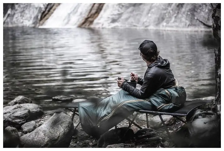 Ein Mann in einem Schlafsack vor einem Fluss