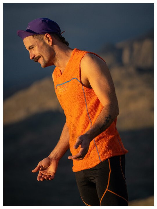 Mann in oranger OMM Core Vest